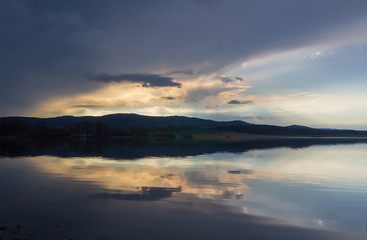 Clear pond with dramatic overcast sky. Nice reflection in water, Czech landscape