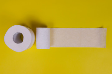 Two rolls of toilet paper on yellow background