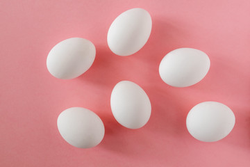 Six white eggs on a pink background. Easter, spring, ingredients for cooking concept. Horizontal orientation.
