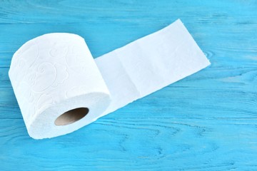 roll of soft toilet paper with selective focus on blue wooden background. toilet paper for Covid-19 pandemic. Increased potential. high demand