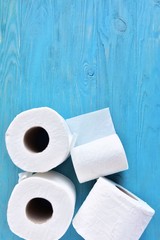 roll of soft toilet paper with selective focus on blue wooden background. toilet paper for Covid-19 pandemic. Increased potential. high demand. Vertical position 
