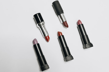 Lipsticks of different colors on wooden background	