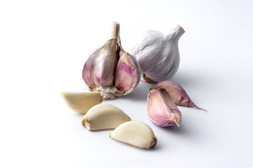 garlic cloves and garlic bulb and white background