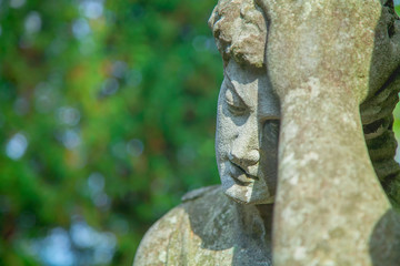 Antique stone statue of sad man on tomb as a symbol of depression, pain and sorrow.