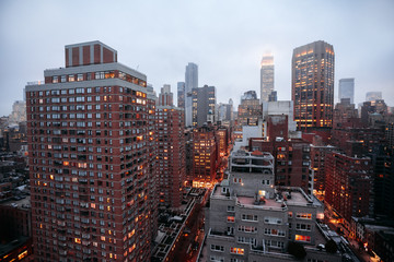Fototapety  Panoramę Nowego Jorku z mglistym niebem, nocnymi światłami i ruchem ulicznym