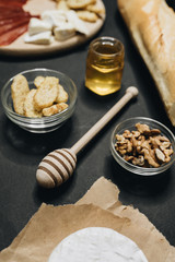Flat lay with assorted food, cheese, bread, meat and nuts on light surface 