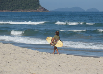 Woman with surfboard on a beach. Surfer on the beach