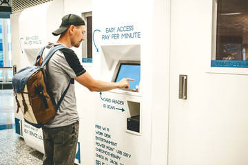 A tourist uses a self service lounge or a smart lounge at the airport for relaxation.