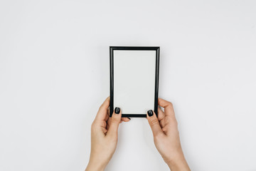 Hands holding a blank photo frame on white background 