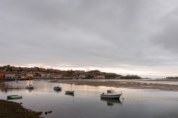 San Vicente de la Barquera, small medieval town in Cantabria, (Spain). Scenic mountain and sea landscape in the north of Spain, with green meadows and boats in a beautiful setting.
