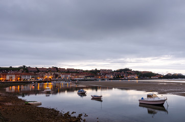 San Vicente de la Barquera, small medieval town in Cantabria, (Spain). Scenic mountain and sea landscape in the north of Spain, with green meadows and boats in a beautiful setting.