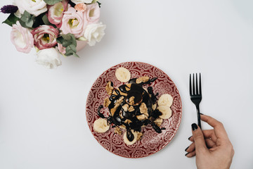Fototapeta premium Stack of delicious homemade pancakes with chocolate topping, walnuts and sliced bananas