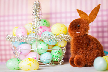 Brown Easter Bunny and a Basket of Colorful Jelly Beans on a Pink Background