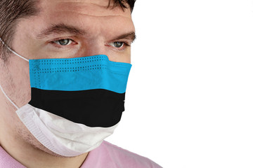 Portrait of adult caucasian man who wears protective mask on his face against influenza and protect health from bacteria. Image of the flag of Estonia.