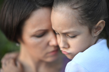 Portrait of sad woman and girl hugging