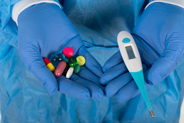 Thermometer and medication in surgeon's hands