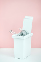 white bucket for sorting recyclables for glass on a pink background with emty space for text