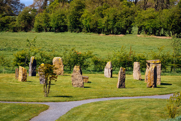 Naklejka premium Ancient megalithic stone formation or monument on green field with forest in the background