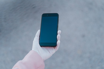 caucasian woman in the street wearing protective mask and using mobile phone. corona virus concept
