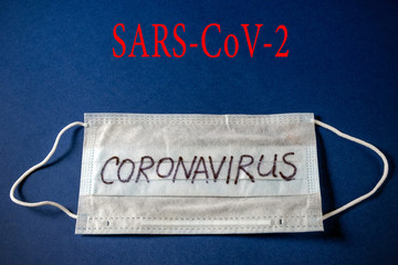 coronavirus - SARS-CoV-2. Surgical mask protective mask with the inscription CORONAVIRUS. New outbreaks of Chinese coronavirus quarantine, on a blue background. world pandemic.