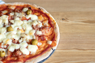 Pizza con jamón, queso, tocino y aceitunas