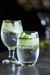 Gin and tonic with cucumber on ice in glass