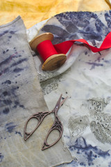 several pairs of old sewing scissors and a spool of red ribbon