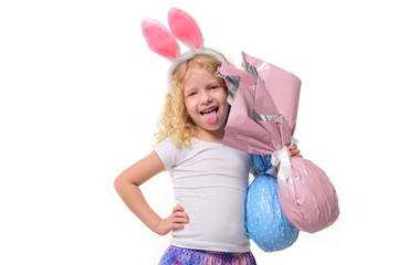 Cute little girl in the Easter bunny ears hugs two stuffed bunnies,  isolated white background. The child smiles. Copy space.