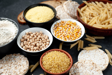 Selection of gluten free food. Chickpeas, bread, couscous, bulgur, pasta, bread, flour, quinoa on a stone background