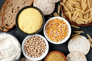 Selection of gluten free food. Chickpeas, bread, couscous, bulgur, pasta, bread, flour, quinoa on a stone background