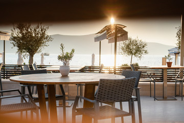 Sunny terrace cafe on the promenade with mountains in the background