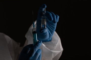 syringe and coronavirus vaccine in the hands of a scientist