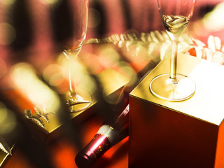 Bottle of pink rose wine and flutes, golden branches and geometrical boxes. Celebration, aperitif concept