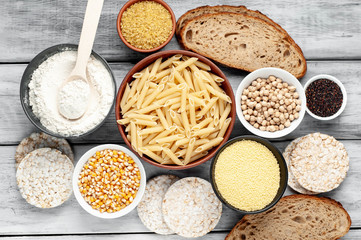 Selection of gluten free food. Chickpeas, bread, couscous, bulgur, pasta, bread, flour, quinoa  on wood background
