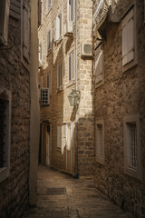 Fototapeta premium Old narrow street of a European city paved with stones