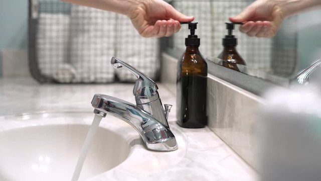 Slider movement of Woman washing her hands with soap and water to prevent spread of germs, bacteria, and viruses