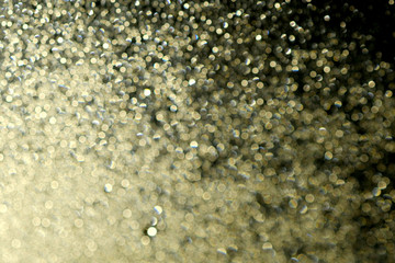 Romantic dreamy golden bokeh. glitter lights grunge background, glitter defocused. Falling flow of golden glitter dust shiny sparkle bokeh abstract background