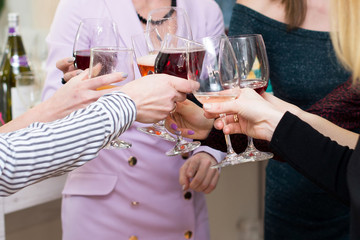 hands with glasses go to celebrate a toast