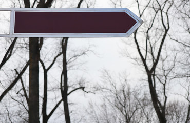 Blank brown pointer in the form of a rectangle for text on a background of trees and sky