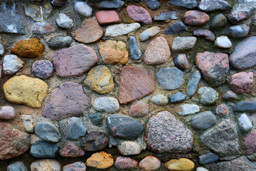 Background of large multi-colored stones in the sand