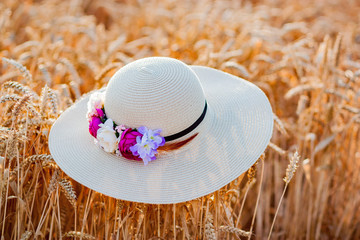 straw hat with flowers in wheat
