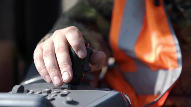 Male hand controls joystick in harvester cab. Harvester remote control. and cuts out the logs on the forest. Lumber industry