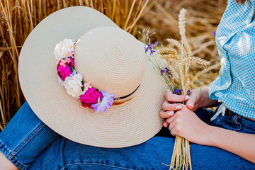 young woman with a straw hat and with wheat