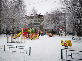 Empty colorful playground in the yard in the park, sports complex in winter