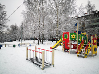 Fototapeta na wymiar Empty colorful playground in the yard in the park, sports complex in winter