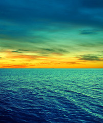 Obraz premium Cyan yellow sea water sky clouds background