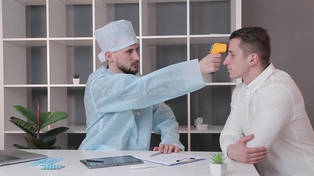 Measurement of human body temperature. The doctor measures the patient's temperature with a non-contact infrared thermometer in the medical office.