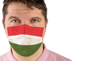 Portrait of adult caucasian man who wears protective mask on his face against influenza and protect health from bacteria. Flag of Hungary.