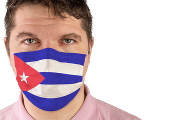 Portrait of adult caucasian man who wears protective mask on his face against influenza and protect health from bacteria. Flag of Cuba.