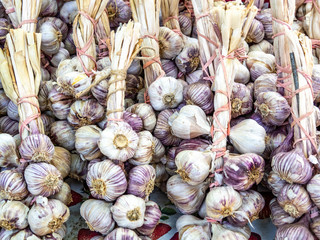 Garlic bulbs in shades of white and purple for sale at Friday market.